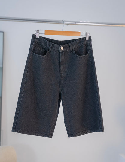 Front view of black Stingem cotton shorts hanging on wooden hanger.