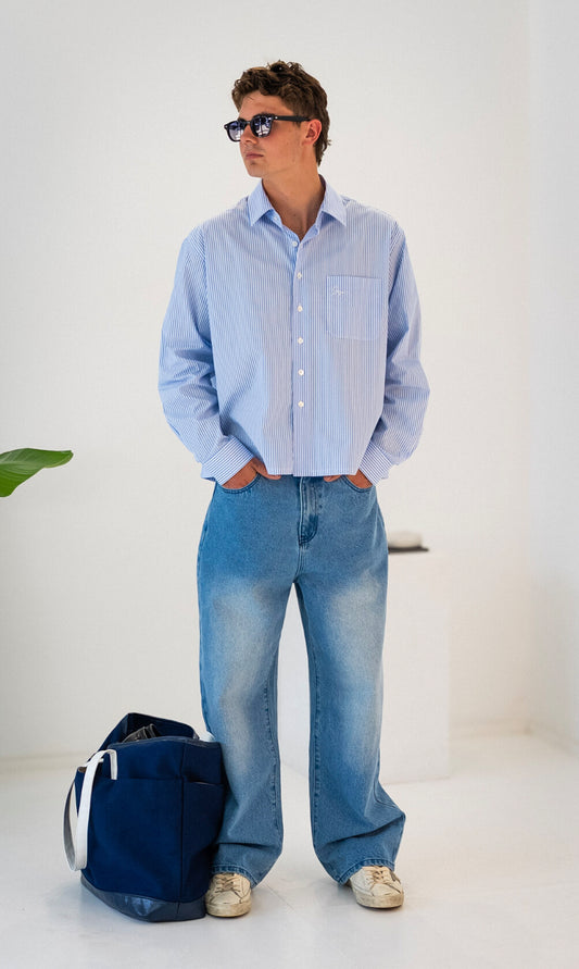 Model wearing white and blue striped Stingem cotton shirt styled with blue denim jeans.