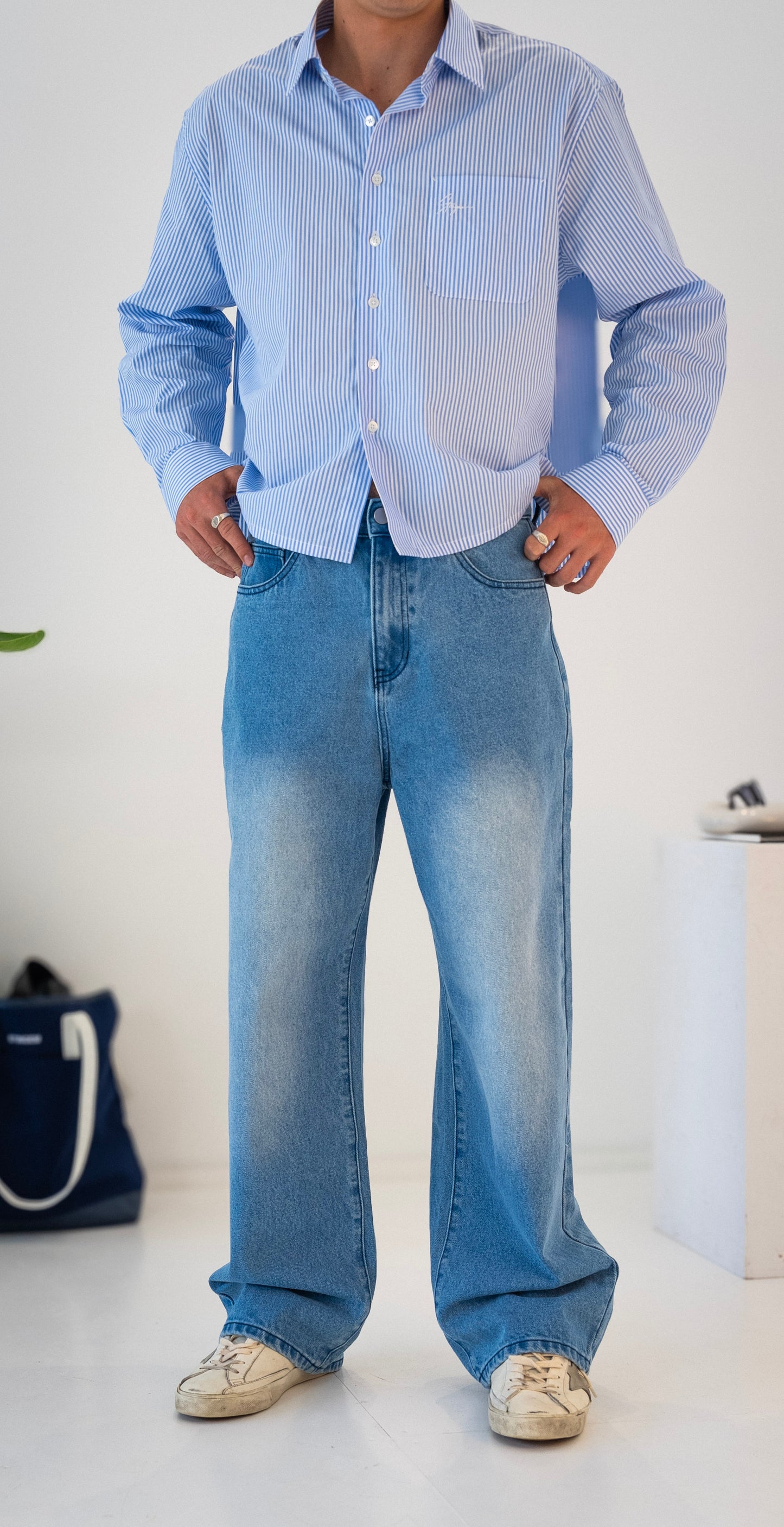 Model wearing blue washed Stingem relaxed fit jeans with white and blue striped shirt.