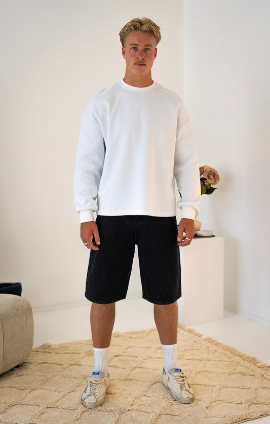 Front view of model wearing white Stingem cotton jumper with boxy fit.